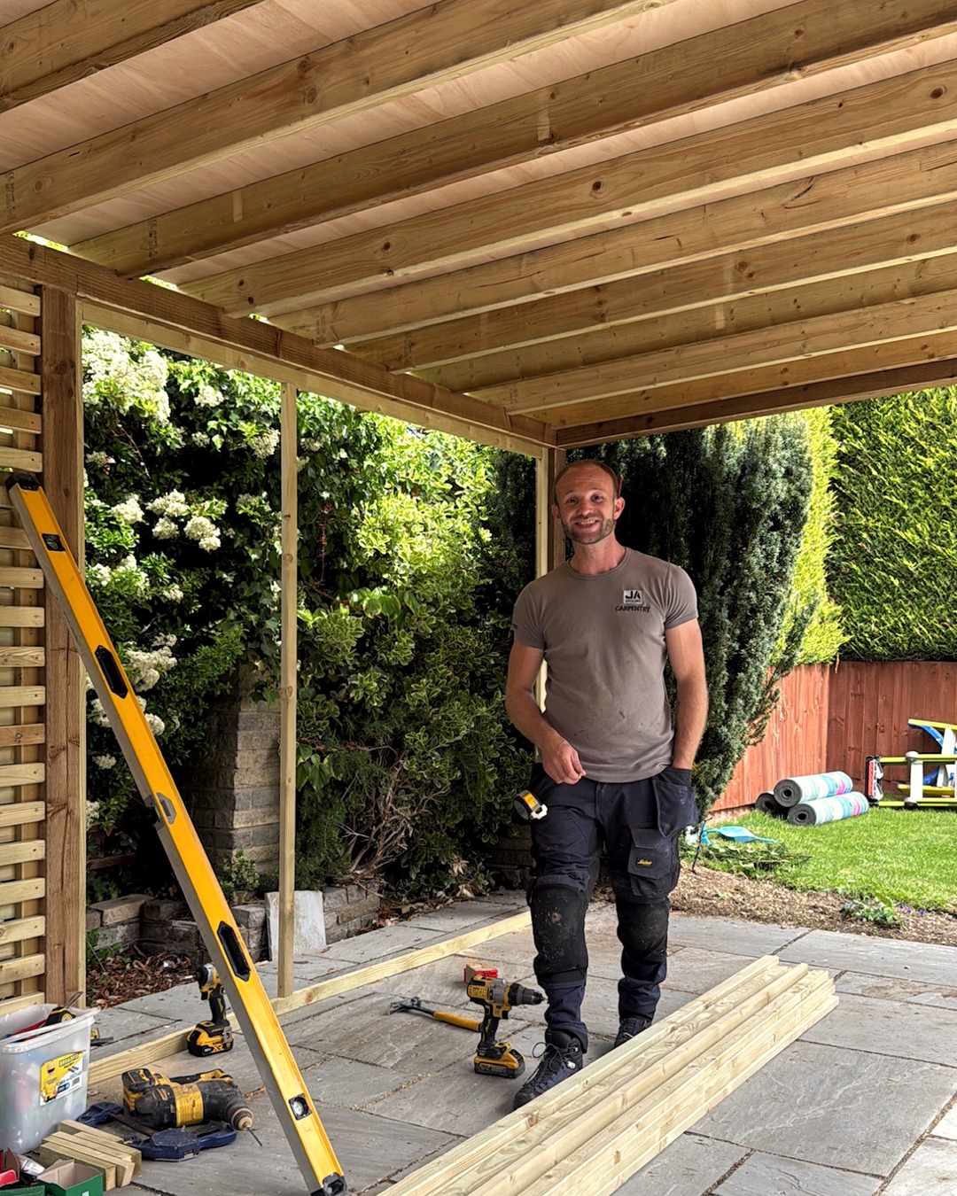 Josh Spoore on site under a timber pergola he is building