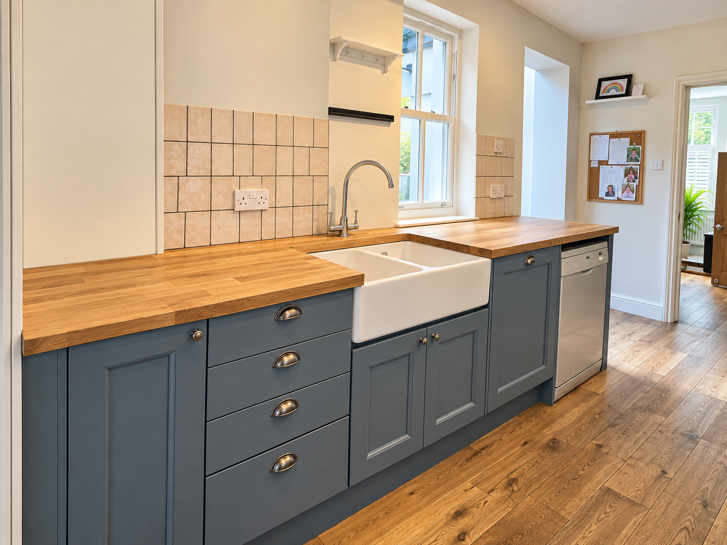 Blue farmhouse-style kitchen with wooden worktops, a Belfast sink and cup handles