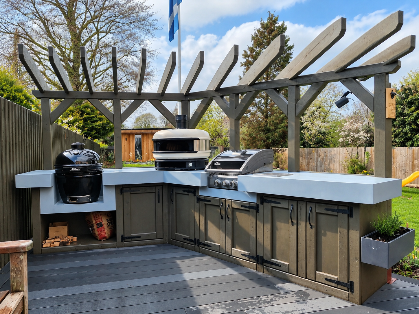 Outdoor kitchen with stained timber cabinets, a pale worktop, an egg grill, a pizza oven and a built-in barbecue under a timber pergola