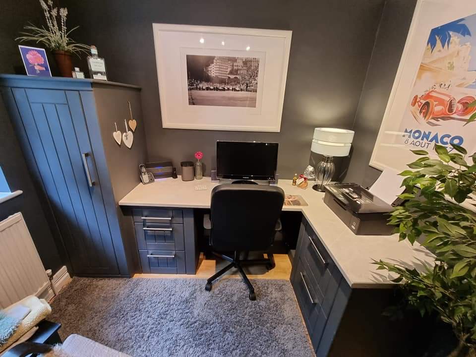 Fitted home office in charcoal grey with an L-shaped corner desk, drawer pedestals, a light worktop and a tall cupboard with grooved shaker doors